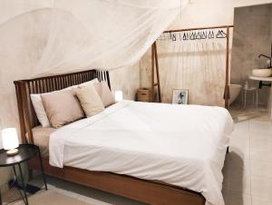 a bedroom with a bed with white sheets and pillows at Tropical Oasis Villa Bukit Bali 2 Pools Golf Cart in Jimbaran