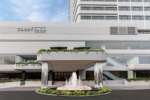 a building with a fountain in front of a building at Courtyard by Marriott Phuket Town in Phuket Town