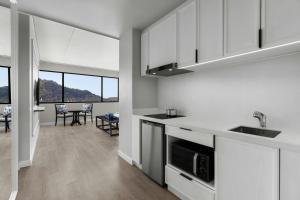 a kitchen with white cabinets and a dining room at Courtyard by Marriott Phuket Town in Phuket Town