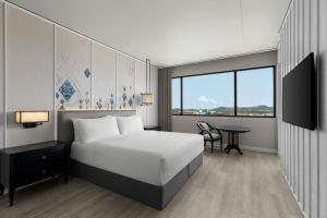 a hotel room with a bed and a table at Courtyard by Marriott Phuket Town in Phuket Town