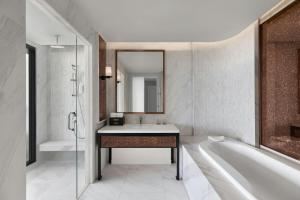 a bathroom with a sink and a tub and a mirror at Courtyard by Marriott Phuket Town in Phuket Town