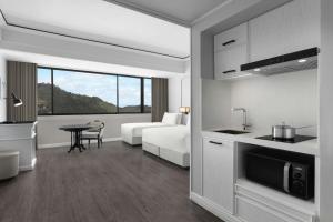 a hotel room with a bed and a kitchen with a table at Courtyard by Marriott Phuket Town in Phuket Town