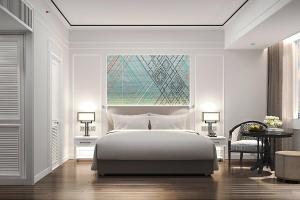 a white bedroom with a bed and a window at Courtyard by Marriott Phuket Town in Phuket Town