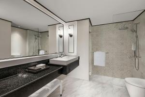a bathroom with a sink and a shower at Courtyard by Marriott Phuket Town in Phuket Town