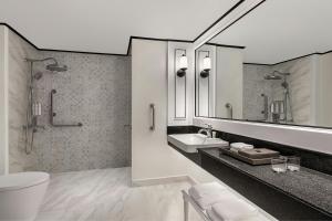 a bathroom with a toilet and a sink and a mirror at Courtyard by Marriott Phuket Town in Phuket Town