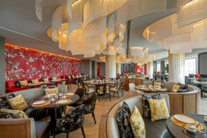 a restaurant with tables and chairs and chandeliers at Courtyard by Marriott Phuket Town in Phuket Town