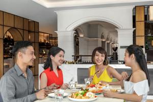 a group of people sitting at a table eating food at Courtyard by Marriott Phuket Town in Phuket Town