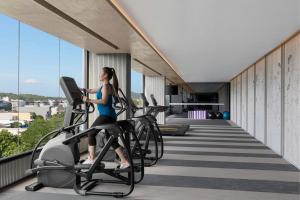 a woman riding on a treadmill in a gym at Courtyard by Marriott Phuket Town in Phuket Town