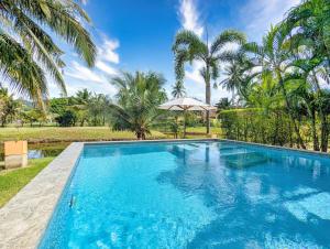 una gran piscina azul con palmeras en Poolside Villa - by KohChangVillas, en Ban Khlong Son 30 fotos más