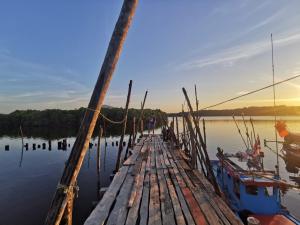 ein Holzsteg mit Booten im Wasser in der Unterkunft Bansuan Sukcharoen at Kuraburi in Khura Buri + 2 Fotos