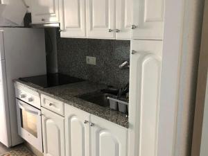 eine Küche mit weißen Schränken und einer Spüle in der Unterkunft VILLAS COSETTE Apartamento Neptuno 417 / Confort total en la Costa Brava: WiFi, piscina y aire acondicionado incluidos! - ES-209-90 in Platja  d'Aro