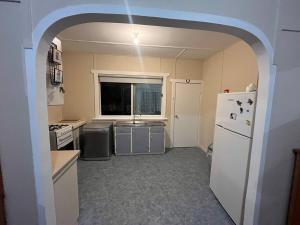a kitchen with a white refrigerator and a window at The Backhouse in Eden
