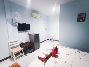 ein Zimmer mit einem Bett, einem Schreibtisch und einem Fernseher in der Unterkunft Bansuan Sukcharoen at Kuraburi in Khura Buri