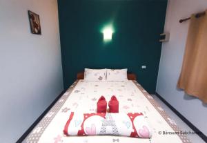 ein Schlafzimmer mit einem Bett mit roten Schuhen darauf in der Unterkunft Bansuan Sukcharoen at Kuraburi in Khura Buri
