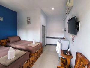 Kleines Zimmer mit 2 Betten und einem TV in der Unterkunft Bansuan Sukcharoen at Kuraburi in Khura Buri