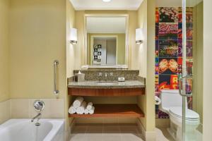 a bathroom with a sink and a tub and a toilet at Renaissance Las Vegas Hotel in Las Vegas
