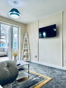 sala de estar con sofá, mesa y TV en Spacious 3BR Home in Colchester, with Private Parking, en Colchester