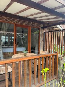 a wooden deck with a table on it at Kalua Boutique Bungalows in Gili Trawangan