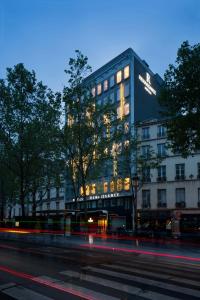 a building on a city street at night at Renaissance Paris Republique Hotel & Spa in Paris