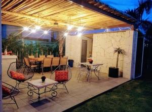 Un patio con mesa, sillas y luces. en Villas ARVEM 1, en Atlixco
