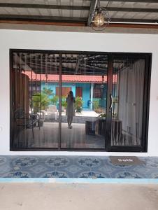 a woman standing outside of a glass window at SK Hometel Samui Airport in Bang Rak Beach