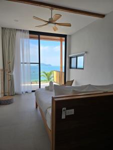 ein Schlafzimmer mit einem Bett und einem Deckenventilator in der Unterkunft Sitaya Beachfront Villas, Koh Phangan in Ko Phangan