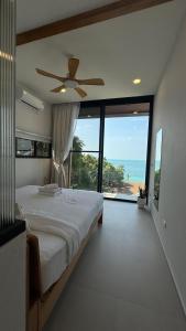 ein Schlafzimmer mit einem Bett und einem Deckenventilator in der Unterkunft Sitaya Beachfront Villas, Koh Phangan in Ko Phangan + 112 Fotos