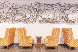 a group of chairs in a room with a painting on the wall at Courtyard by Marriott Thousand Oaks Agoura Hills in Agoura Hills