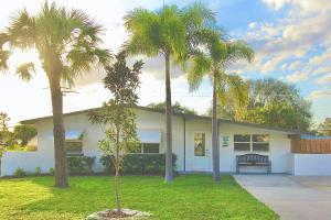 a house with palm trees in front of it at Jensen Surf Shack in Jensen Beach