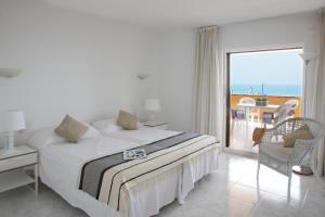 a bedroom with a bed and a view of the ocean at Apartaments Beach & Golf Resort in Pals