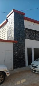 ein Gebäude mit einem davor geparkten Auto in der Unterkunft Departamento y Alberca privada in Yelateni + 2 Fotos