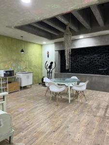 ein Esszimmer mit Glastisch und Stühlen in der Unterkunft Departamento y Alberca privada in Yelateni