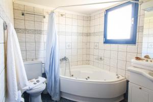 a white bathroom with a tub and a toilet at Mantilida Villa & Studio in Kissamos