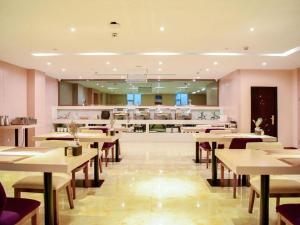 a restaurant with tables and chairs and a counter at Lavande Hotels Jinzhong Youjian Pingyao in Jinzhong