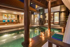 a swimming pool in a villa with a living room at Villa Green Manggo Seminyak Bali in Seminyak