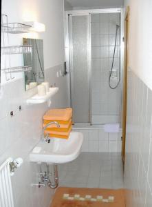 La salle de bains blanche est pourvue d'un lavabo et d'une douche. dans l'établissement Haus Wald-Eck, à Schmallenberg