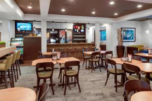 a dining room with wooden tables and chairs at Courtyard by Marriott Portsmouth in Portsmouth