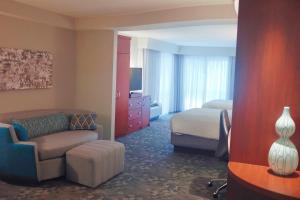a hotel room with a couch and a bed at Courtyard by Marriott Owensboro in Owensboro +15 photos