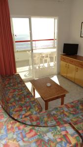 1 dormitorio con 2 camas, mesa y balcón en Apartamentos Beni-Beach, en Benidorm