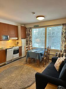 a kitchen and living room with a table and a couch at Outapailakka K19 in Saariselka