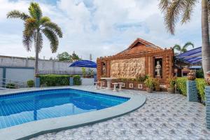 ein Haus mit einem Pool und einem Gebäude in der Unterkunft D Pool Villa Pattaya in Nong Prue