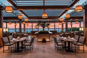 a dining room with tables and chairs and lights at Renaissance Polat Istanbul Hotel in Istanbul