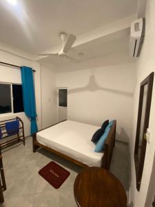 a bedroom with a bed and a table and a ceiling at The Fort House - Matara in Matara
