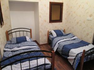 two twin beds in a room with a mirror at Double gates home in Baku