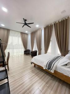 a bedroom with a bed and a ceiling fan at Villa Aainaa Homestay in Pasir Mas +20 photos
