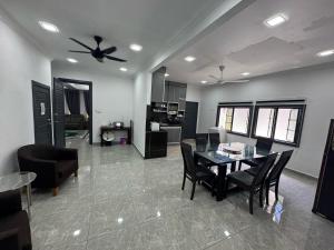 a kitchen and dining room with a table and chairs at Villa Aainaa Homestay in Pasir Mas