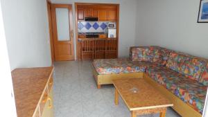 ein Wohnzimmer mit einem Sofa und einem Tisch in der Unterkunft Apartamentos Beni-Beach in Benidorm