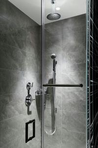 a shower with a glass door in a bathroom at AC Hotel by Marriott Raleigh North Hills in Raleigh