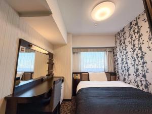 a hotel room with a bed and a mirror at APA Hotel Shibuya Dogenzakaue in Tokyo