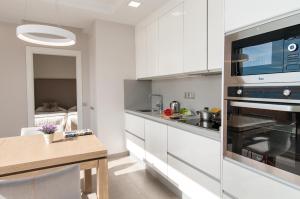 cocina con armarios blancos y fogones en Apartment Las Canteras Nautilus 8D, en Las Palmas de Gran Canaria